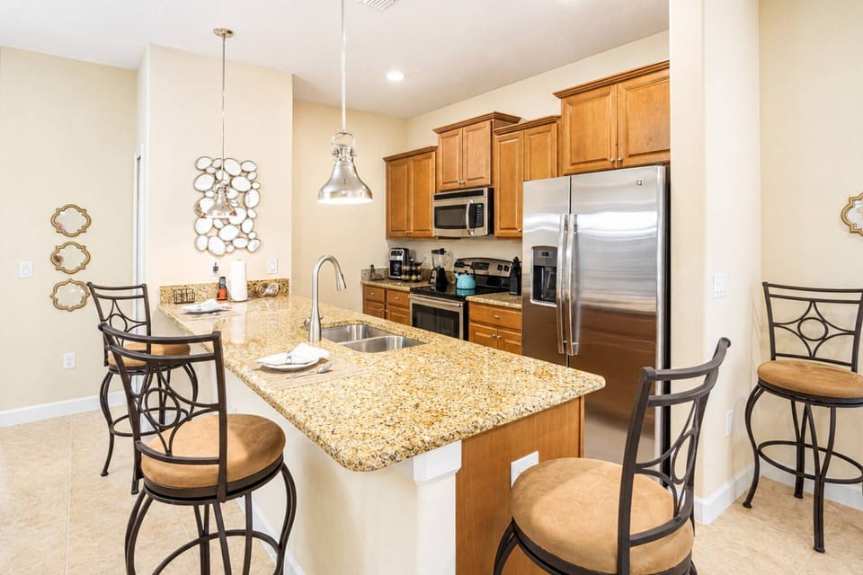 Gourmet fully equipped kitchen with stainless steel appliances, granite counters, and bar seating for 3 or 4 guests