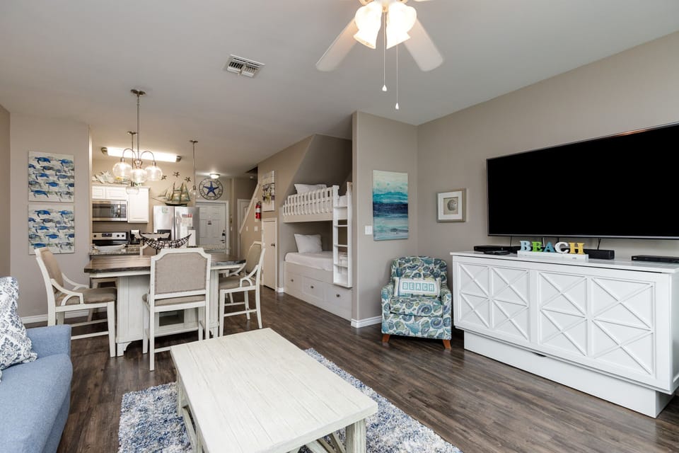 Your coastal-themed living space seamlessly blends comfort with function, featuring bunk beds and an open kitchen perfect for family gatherings.