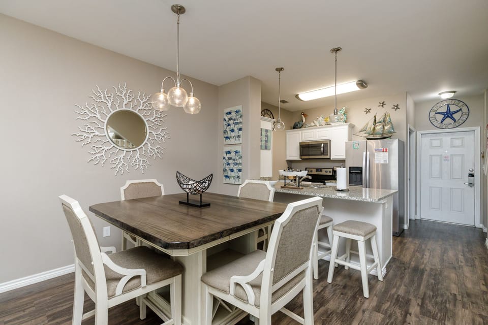 Gather around your spacious dining table for memorable meals, with a fully equipped kitchen featuring modern appliances and coastal charm throughout.