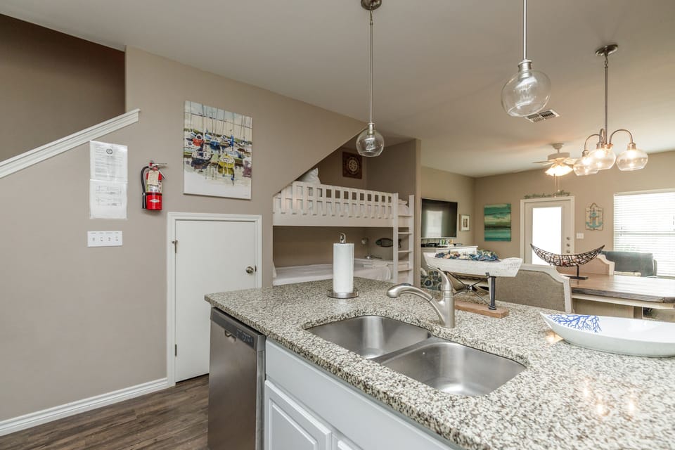 Your open kitchen with granite counters flows seamlessly into the living space, where bunk beds and pendant lighting create a cozy family retreat.