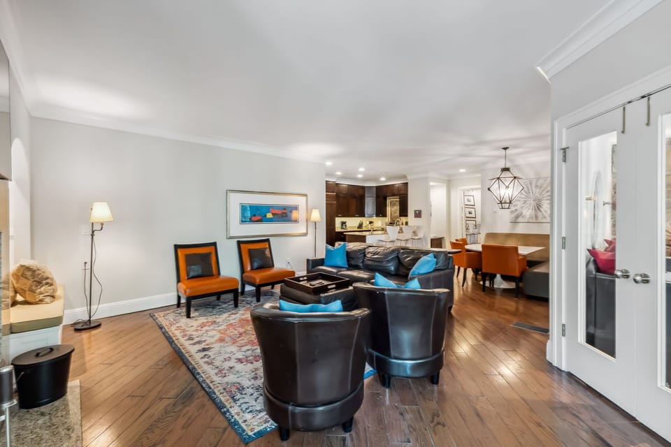 Unwind in this sophisticated living space featuring rich hardwood floors, plush leather seating, and vibrant artwork that creates the perfect atmosphere for relaxation.