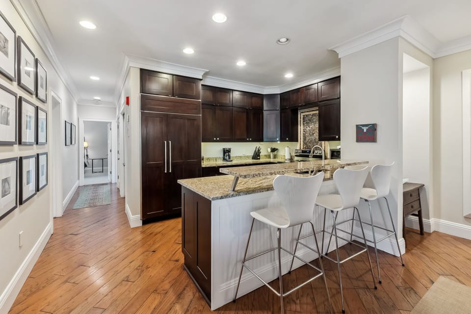 Your gourmet kitchen features rich wood cabinetry, granite countertops, and a stylish breakfast bar where you can enjoy morning coffee.