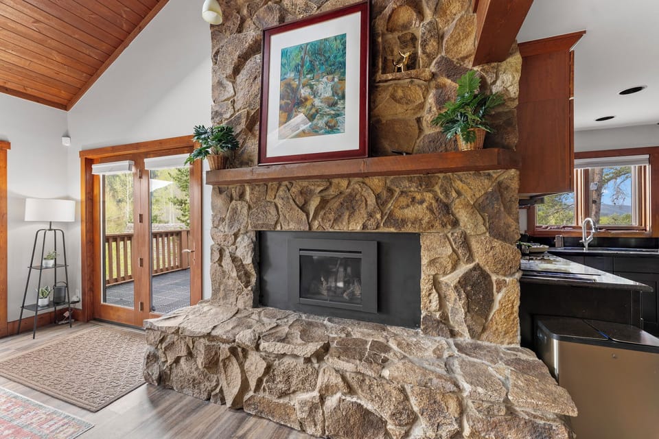 Cozy up by your stunning stone fireplace while enjoying views of nature through French doors leading to your private deck.