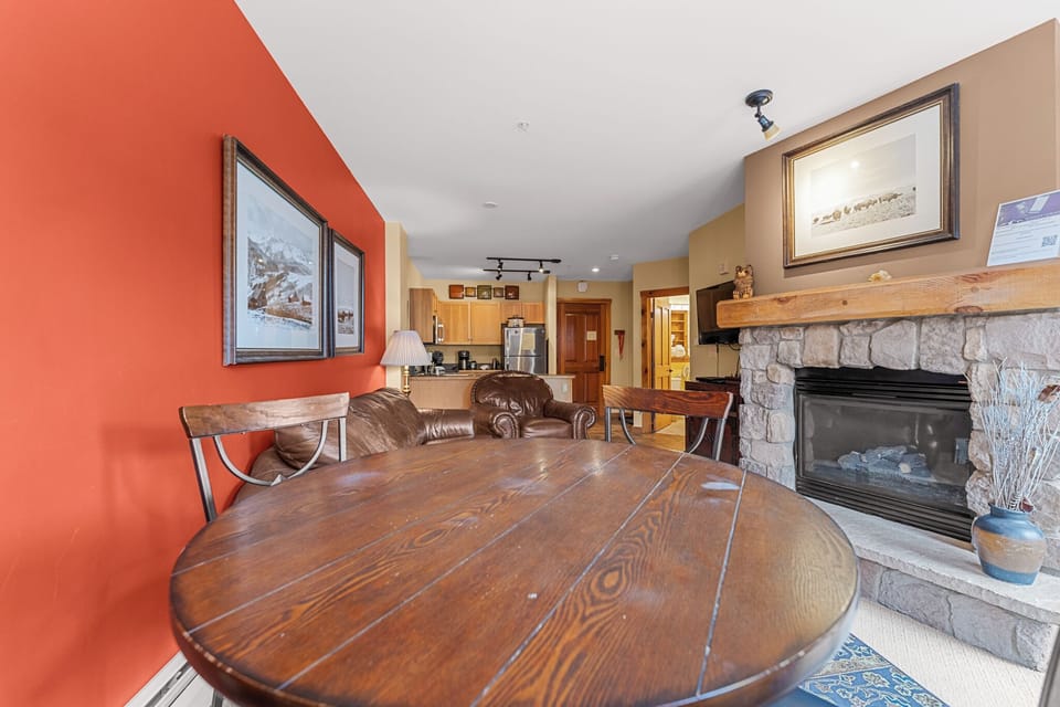 Gather around the rustic dining table while the fireplace crackles nearby, creating the perfect mountain retreat atmosphere.