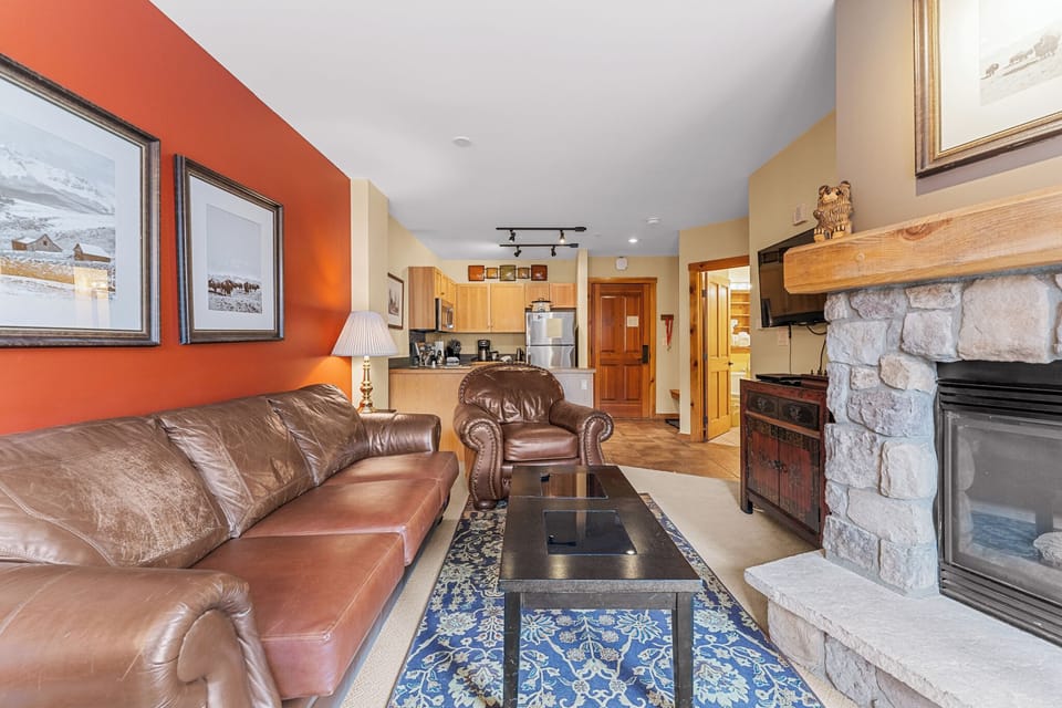 Cozy up in your inviting living room featuring rich leather seating and a stone fireplace for perfect mountain evenings.