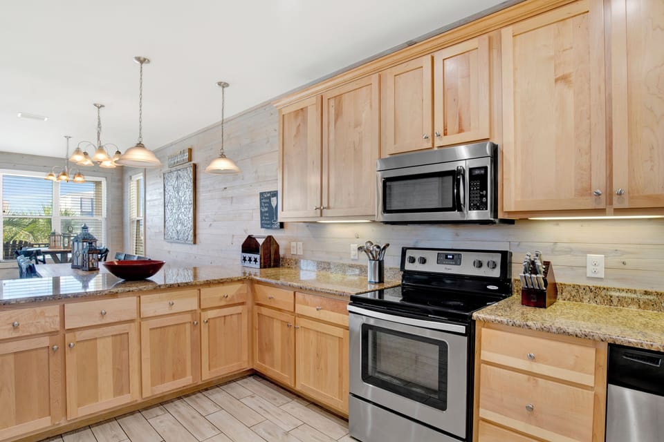 Spacious kitchen with stone counters and stainless appliances
