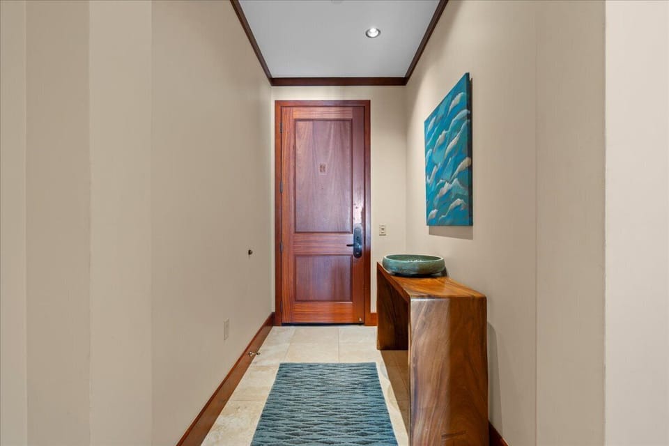 Step through your private entrance into a welcoming foyer where coastal-inspired artwork and warm wood accents set a relaxing tone for your stay.