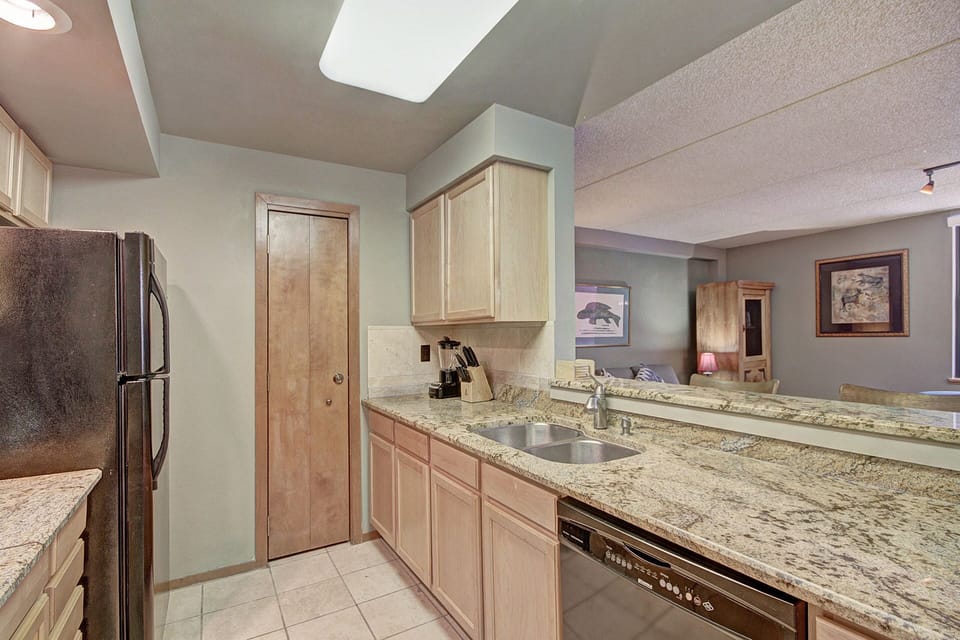 Kitchen with bar stool seating area looking into living room