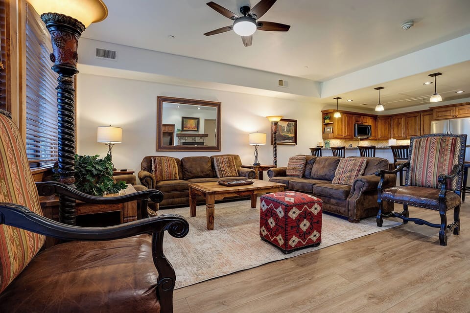 Sink into plush leather sofas in your spacious living room, where southwestern charm meets modern comfort for perfect relaxation.