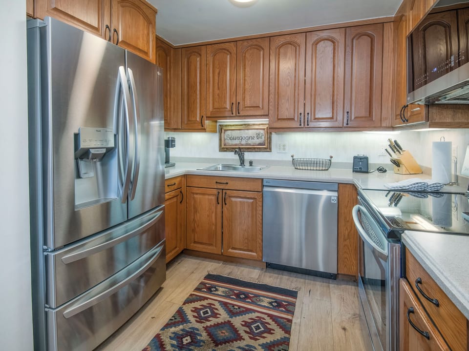 Your fully equipped kitchen features stainless steel appliances and rich wood cabinetry, perfect for preparing memorable meals during your stay.