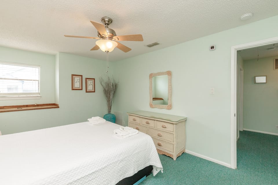 Relax in your peaceful bedroom with soft mint walls, a cozy ceiling fan, and fresh linens waiting for you.