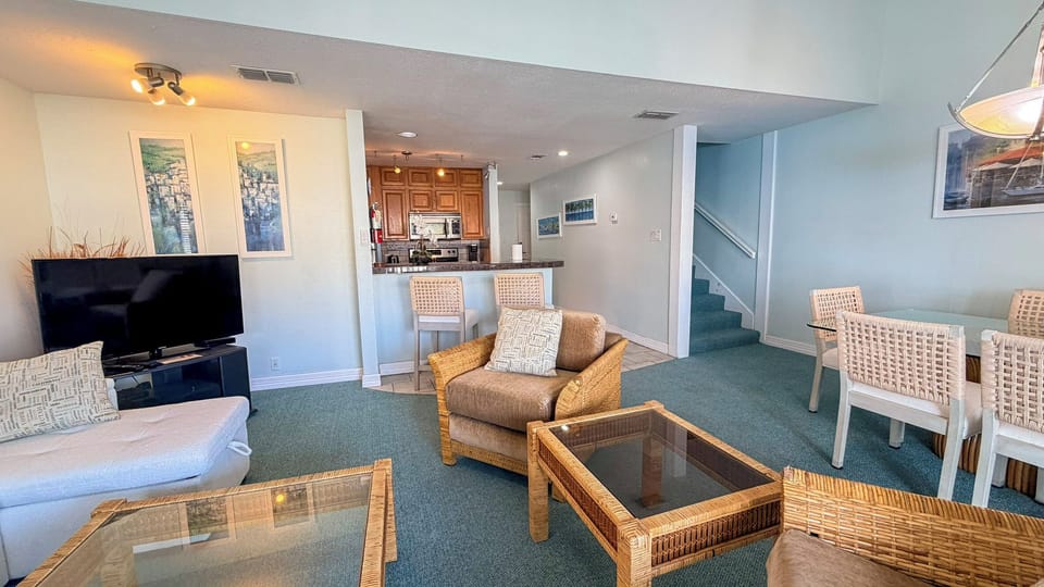 Unwind in your spacious retreat with coastal vibes—wicker furnishings, open kitchen, and dining area create the perfect space for relaxation.