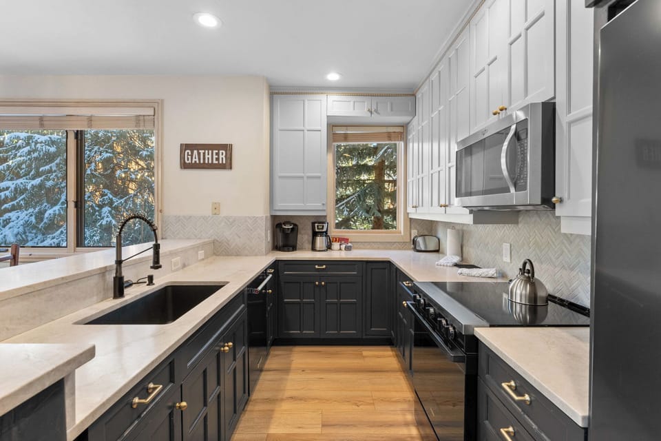 Full kitchen featuring stainless steel appliances, and breakfast bar seating 4.
