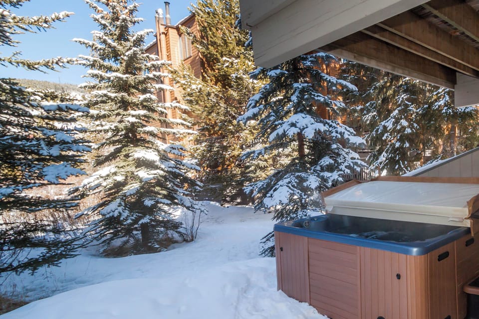 Soak in your private hot tub surrounded by snow-dusted evergreens and mountain charm—pure winter bliss awaits.