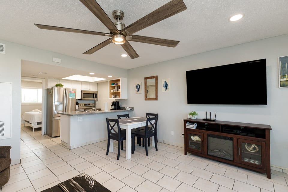 Relax in your open-concept living space with modern kitchen, dining area, and entertainment center—perfect for unwinding after beach days.