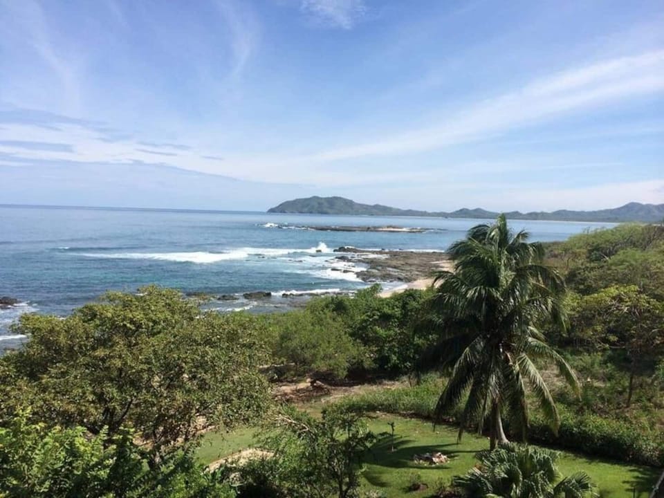 Stunning ocean view from the balcony featuring San Francisco Point and Capitán Island in the distance. A signature Tamarindo scene from this luxury condo near Langosta Beach, perfect for nature lovers and sunset seekers.