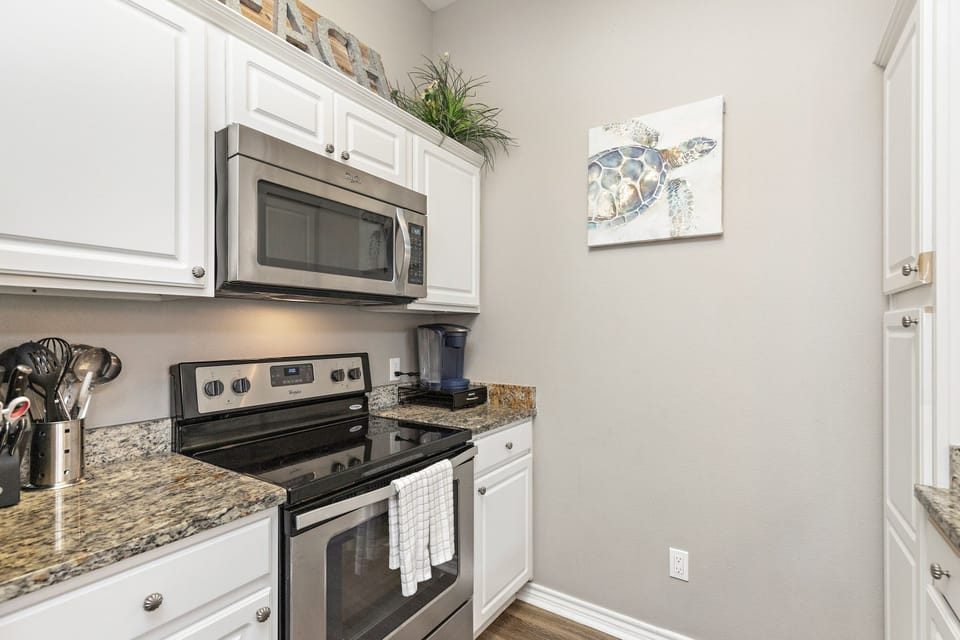 Cook your favorite meals in your fully equipped kitchen featuring granite counters, stainless appliances, and charming coastal artwork.