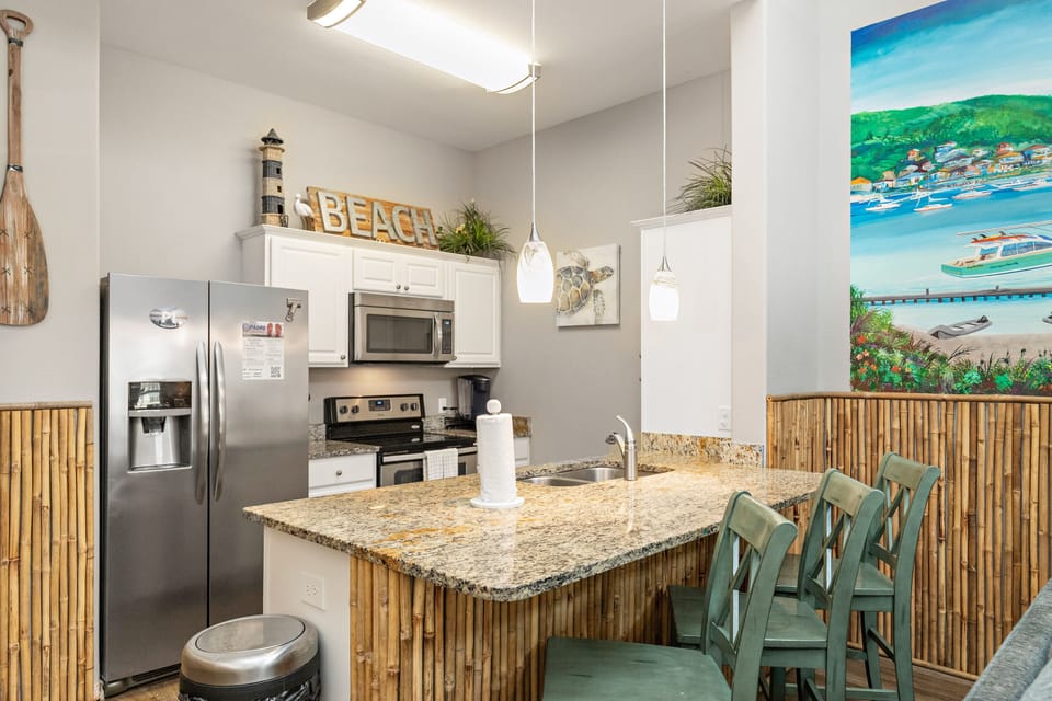Your beach-themed kitchen invites coastal living with bamboo accents, granite counters, and tropical artwork creating your perfect island getaway.