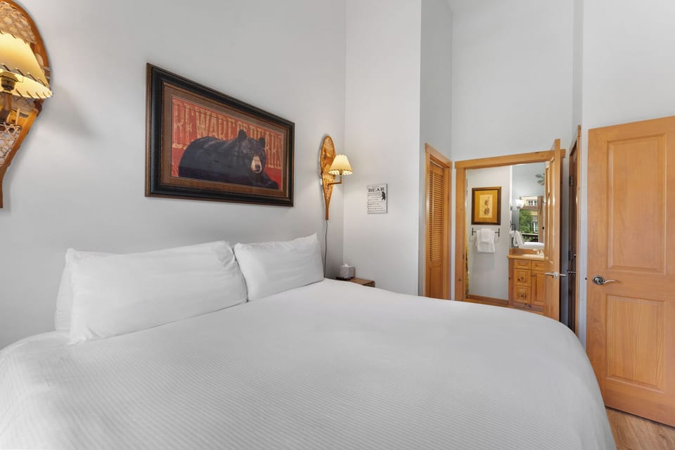 Primary bedroom with a king bed, premium bedding, and en suite bathroom.