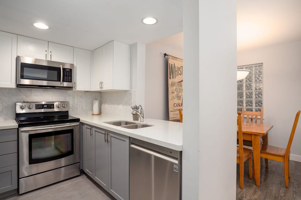 Fully equipped modern kitchen with stainless steel appliances.