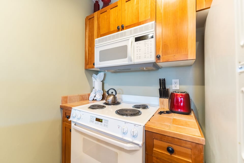 Your fully equipped kitchen awaits with warm wood cabinets, modern appliances, and thoughtful touches like fresh towels and quality cookware for memorable meals.
