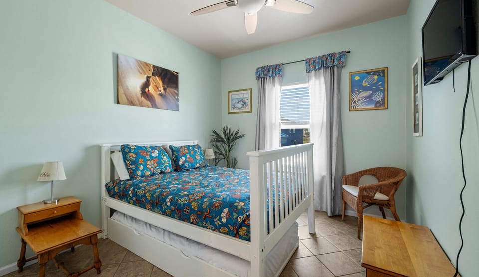 Bedroom — full bed with trundle, blue floral bedding & fish art