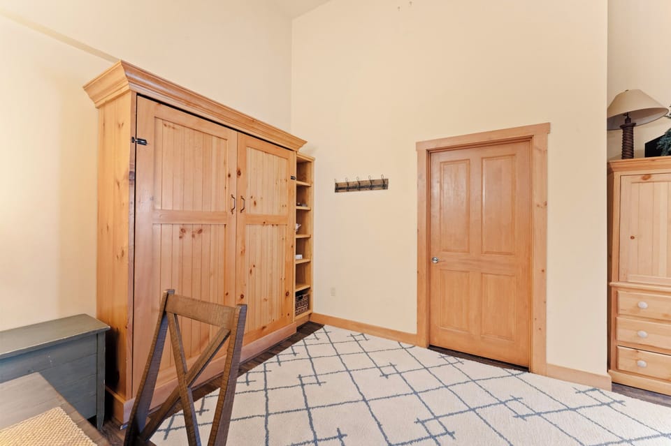 Spacious living room with a mounted TV, gas fireplace, queen sleeper sofa, and queen Murphy bed.