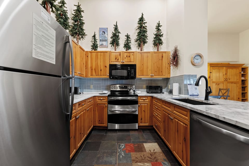 Your fully equipped kitchen features warm wood cabinets, granite counters, and modern stainless appliances—perfect for creating memorable meals during your stay.