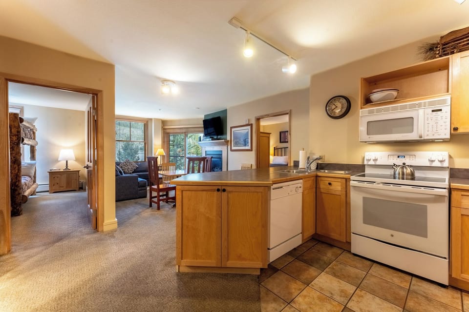 Your spacious kitchen flows seamlessly into the living area, featuring warm wood cabinetry and modern appliances for memorable meals together.