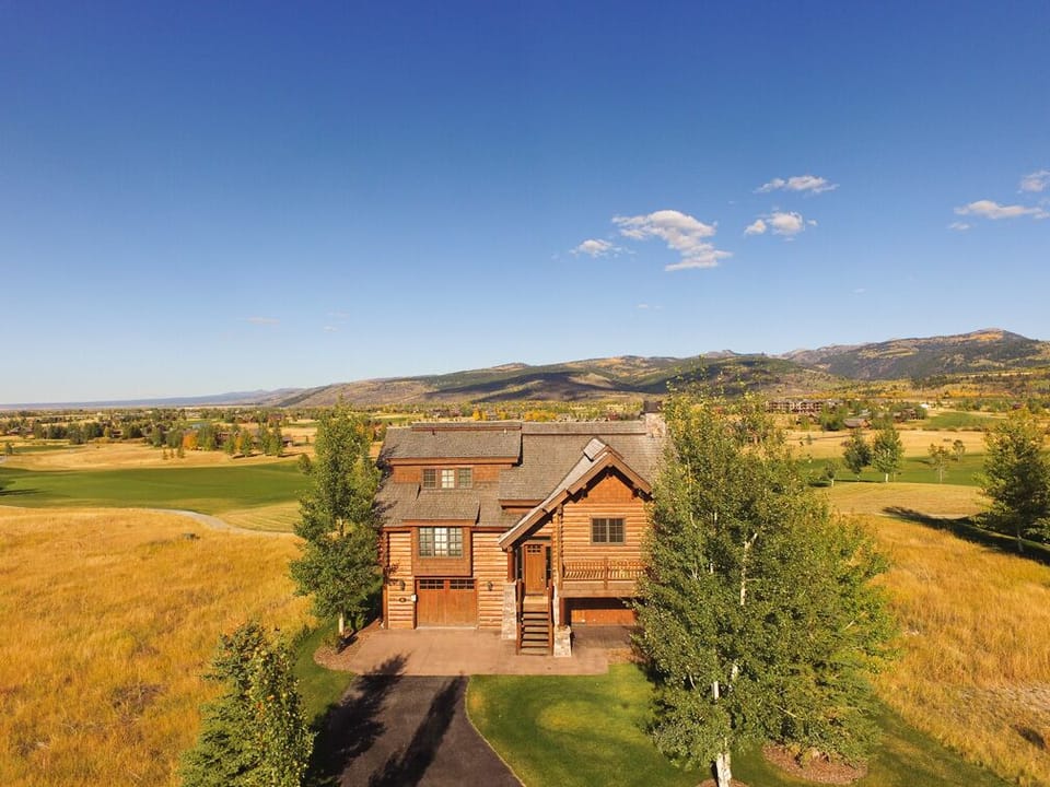 Step into your mountain retreat where golden meadows stretch endlessly around your private wooden sanctuary, with breathtaking valley views that will take your breath away every morning.