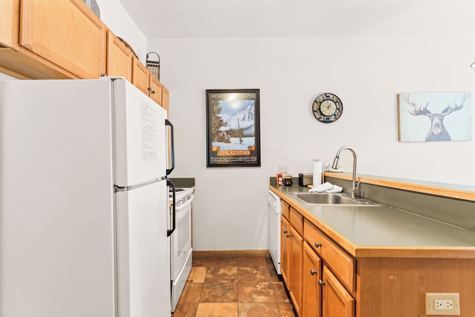 Cook your favorite meals in this fully equipped kitchen with warm wood cabinets, modern appliances, and mountain-inspired decor.