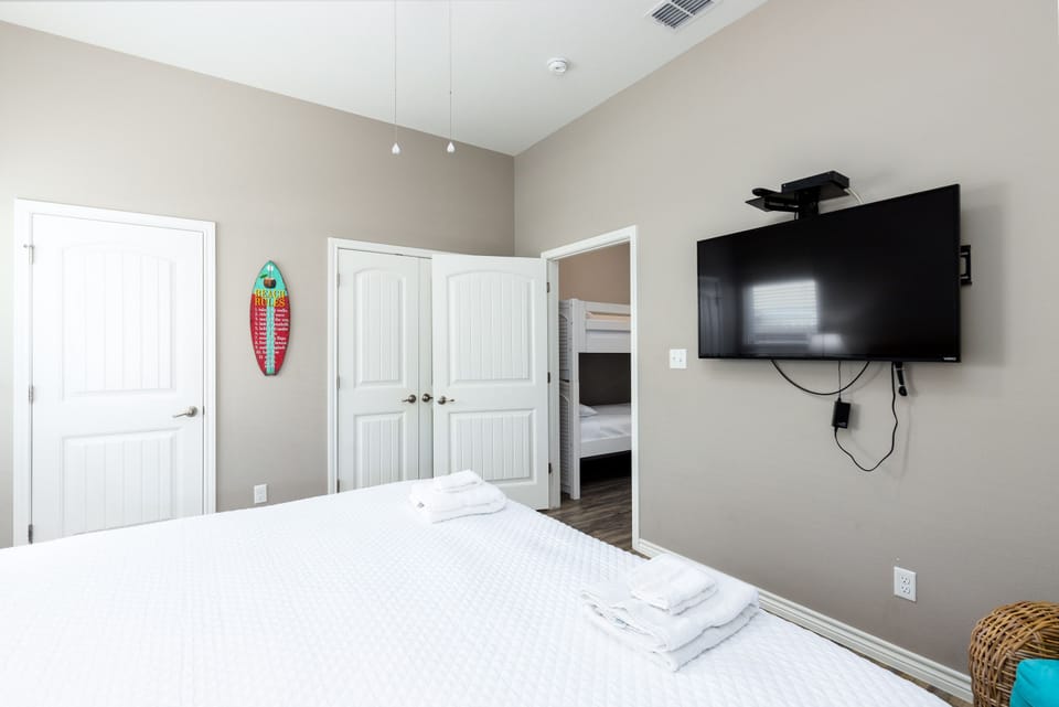 Relax in your peaceful bedroom with modern comforts, including a wall-mounted TV and convenient closet storage for all your belongings.