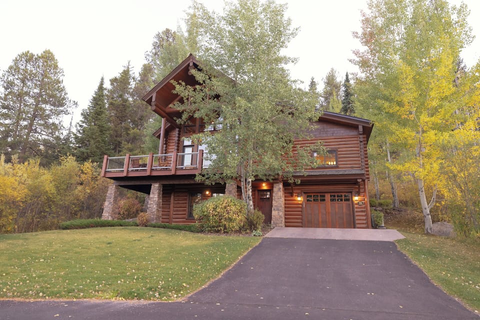 Your stunning log cabin retreat awaits, nestled among golden aspens with a welcoming stone-accented entrance and private balcony where you can sip your morning coffee while listening to nature's symphony.