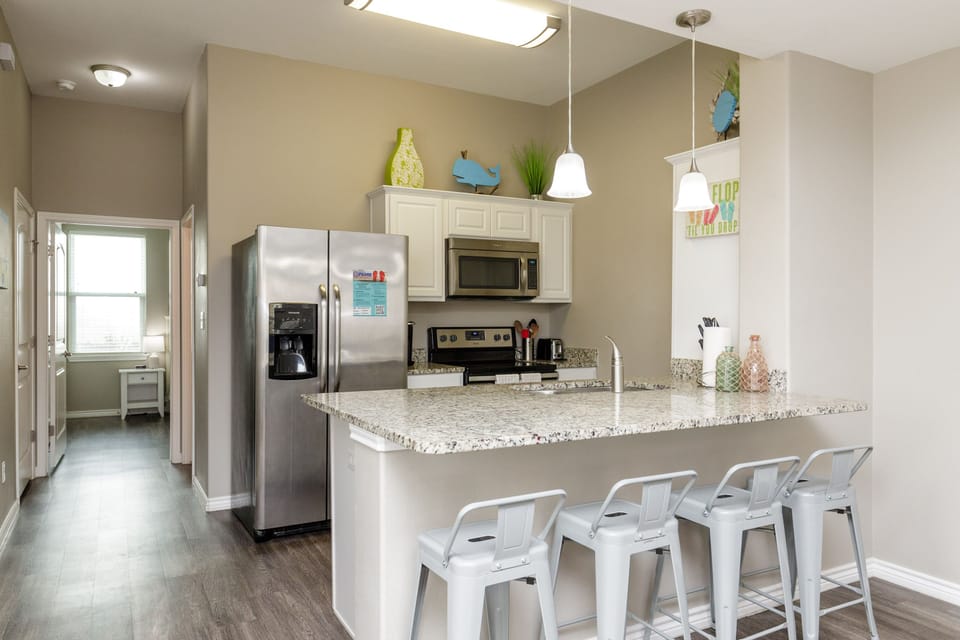 Your bright open kitchen features granite countertops, stainless steel appliances, and a breakfast bar perfect for morning coffee or casual meals.