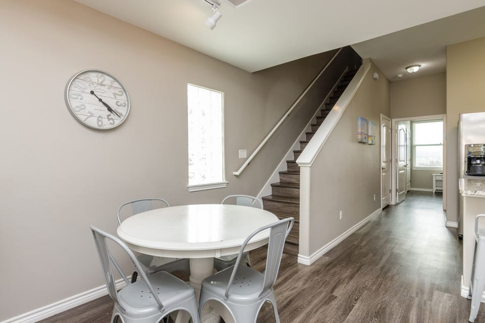 Your open dining space flows seamlessly with modern charm, featuring a bright white table perfect for morning coffee or evening meals together.
