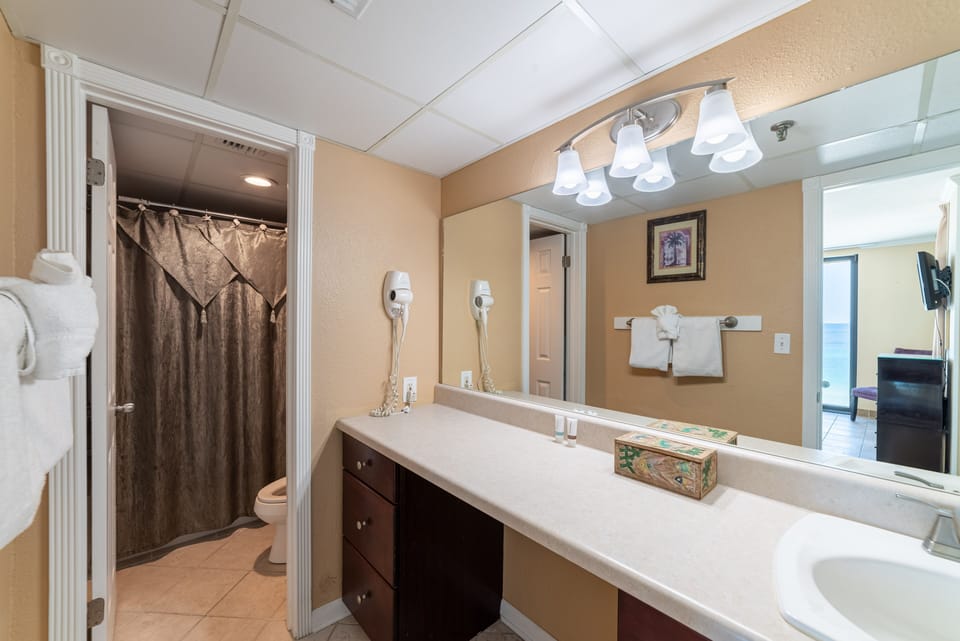 The master bath has a separate dressing area with single vanity and lots of storage.