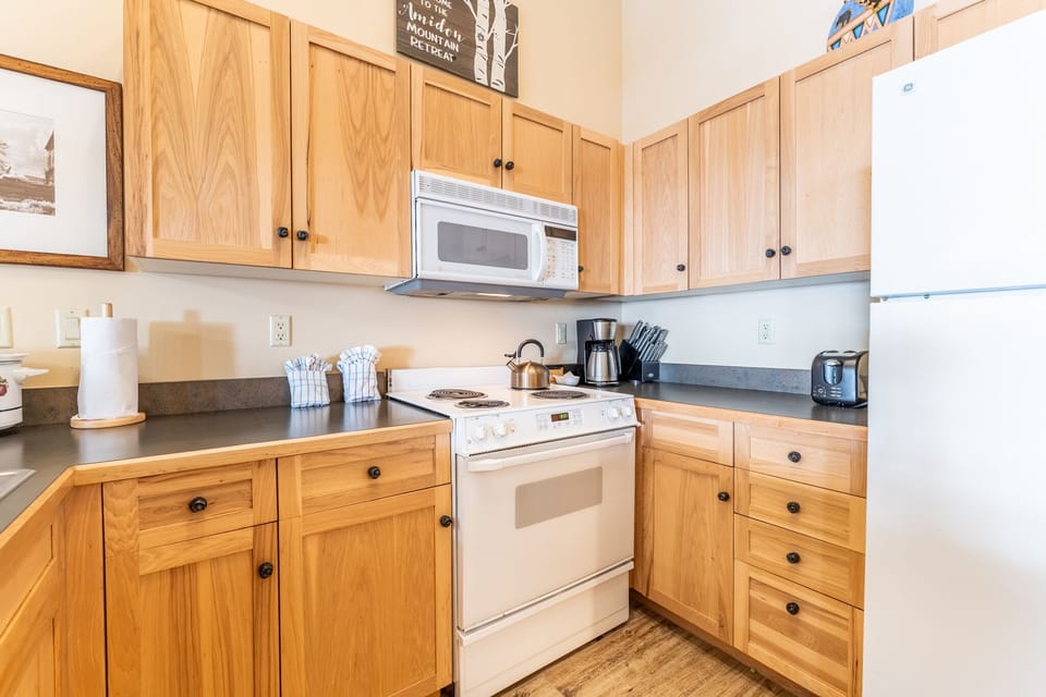 Full size kitchen with vaulted ceilings and hardwood flooring.