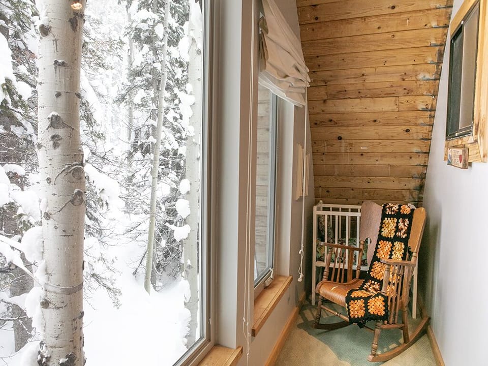 Downstairs Mud Room - Downstairs mud room with outdoor view, rocking chair and crib.