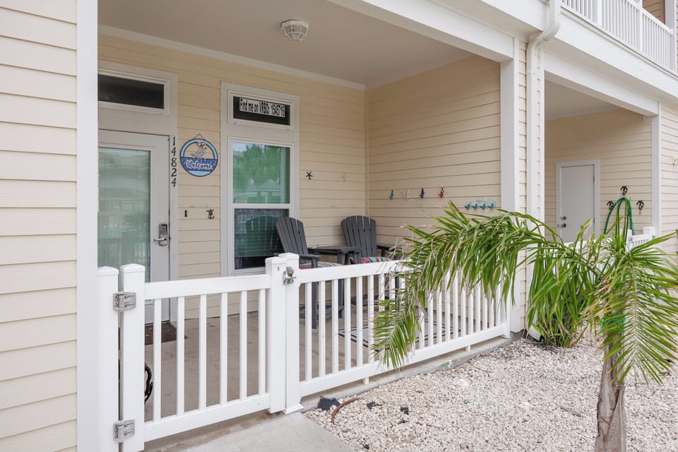 Your welcoming front porch with comfortable Adirondack chairs and tropical palms creates the perfect spot to unwind.