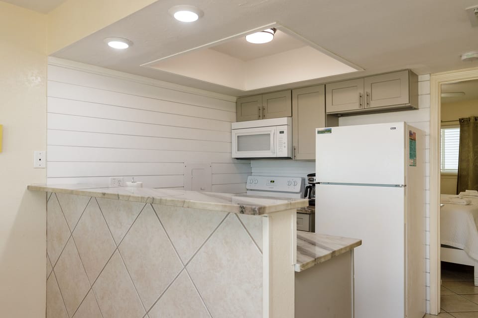 Cook with ease in your fully equipped kitchen featuring modern appliances, ample counter space, and charming coastal-inspired design.