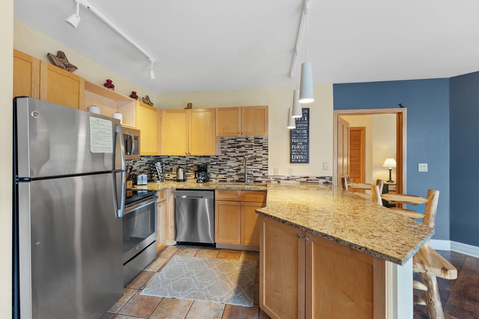 Your fully equipped kitchen features granite counters, stainless appliances, and a breakfast bar perfect for morning coffee or quick meals.
