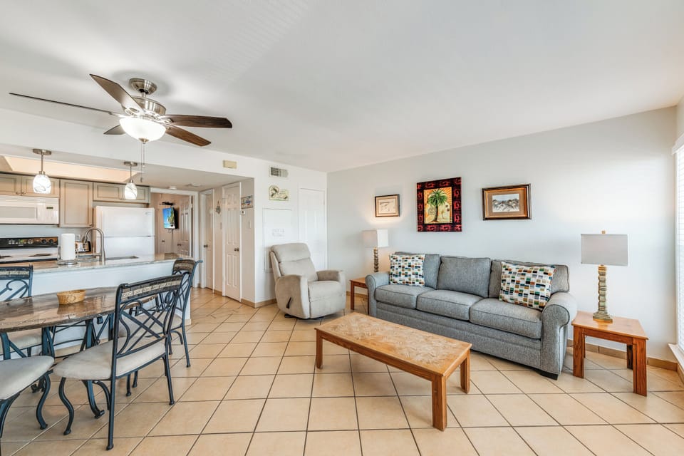 Relax in your bright, open-concept living space featuring comfortable seating, modern kitchen, and coastal charm throughout.