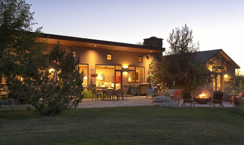 Imagine your evenings unfolding on this stunning patio, where warm lights beckon you to gather around the crackling fire pit as twilight paints the sky in gentle hues.