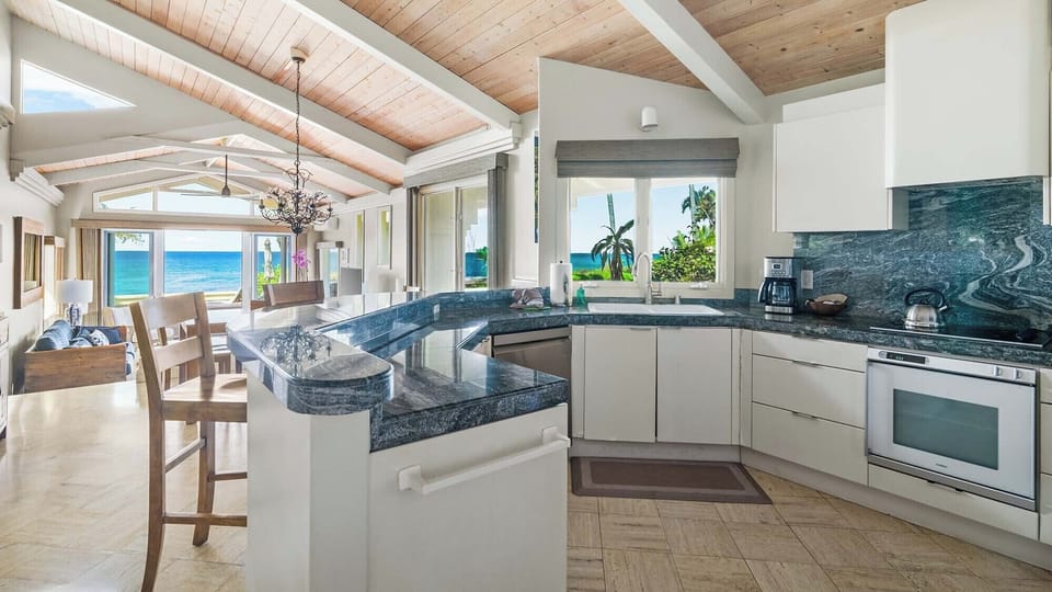 Gorgeous sea views frame this bright, open kitchen where you'll love preparing meals while taking in the stunning coastal scenery through every window.
