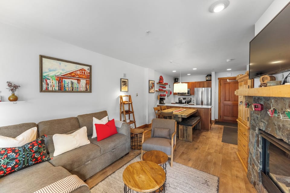 Relax in your cozy living room with plush seating, warm fireplace, and open kitchen perfect for preparing meals together.