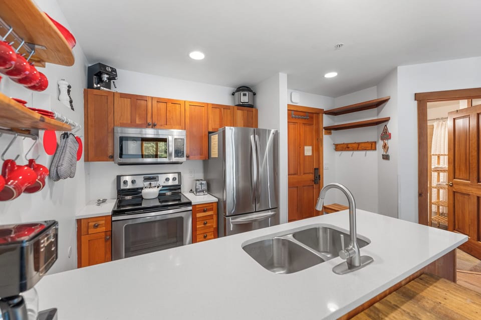 Your fully equipped kitchen awaits with gleaming stainless appliances, rich wood cabinets, and ample counter space for culinary adventures.