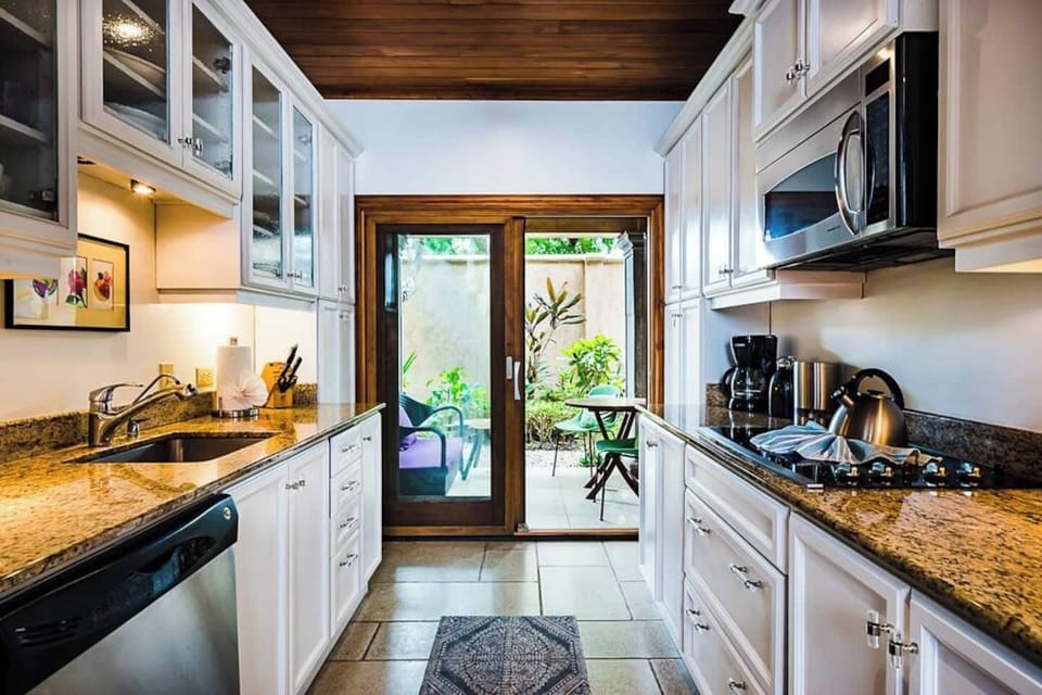 Fully equipped kitchen with everything you need to prepare meals, opening onto a cozy patio with a BBQ area — ideal for a relaxing family vacation.