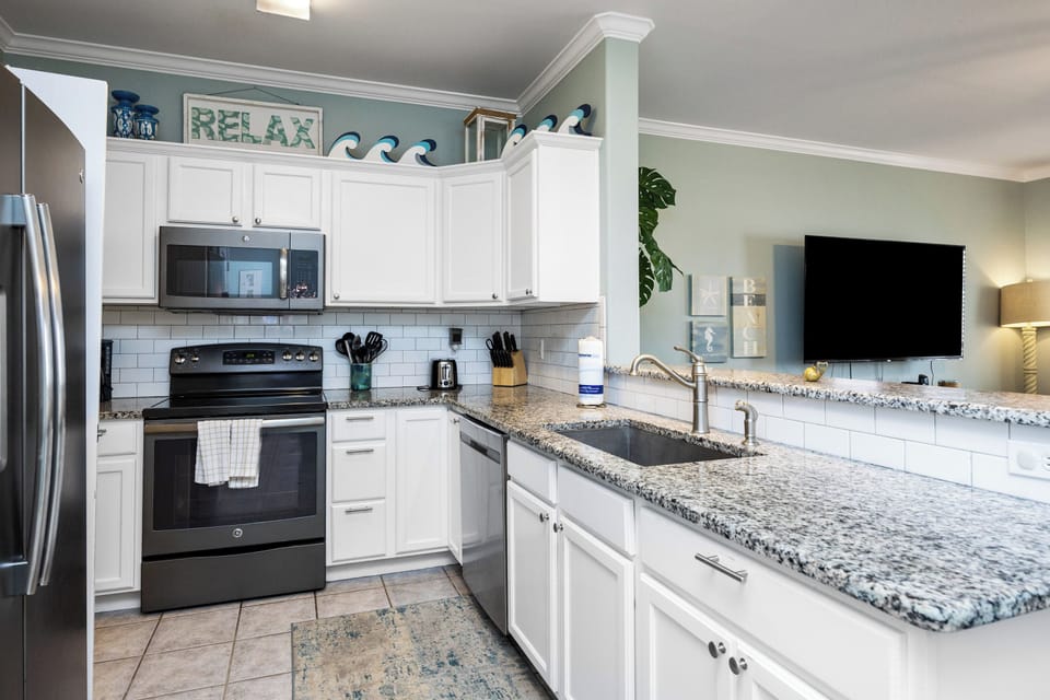 Your fully-equipped kitchen awaits with granite counters, modern appliances, and coastal charm for creating memorable vacation meals together.