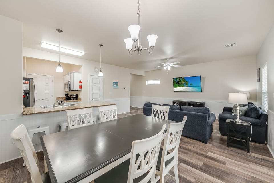 Relax in your spacious open-concept living area where the dining table flows seamlessly into the cozy living room with large TV for memorable evenings together.