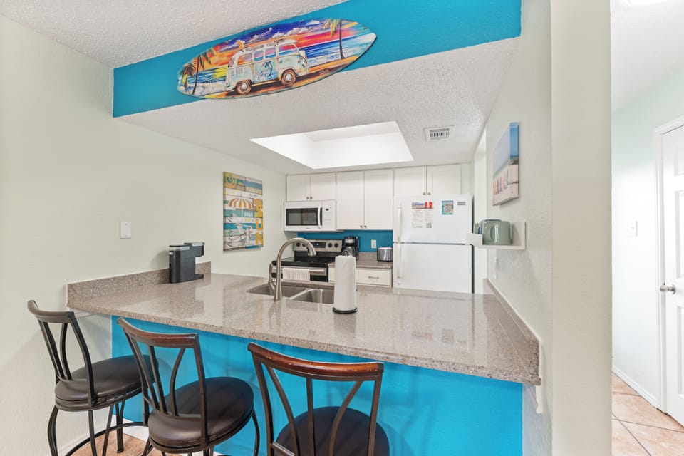 Your bright, beach-themed kitchen invites you to whip up meals with modern appliances and a fun breakfast bar for casual dining.